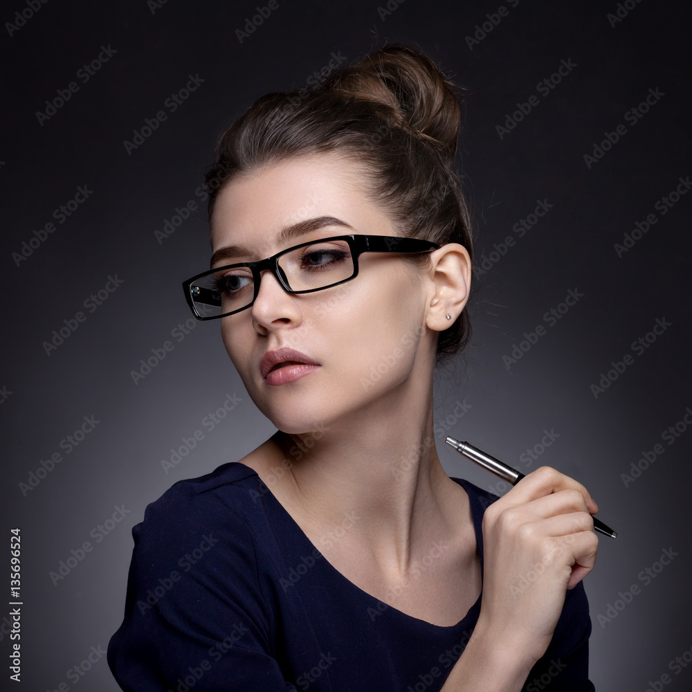 Portrait of a beautiful woman in a business style. On a gray bac Portrait of a beautiful woman in a business style. On a gray bac