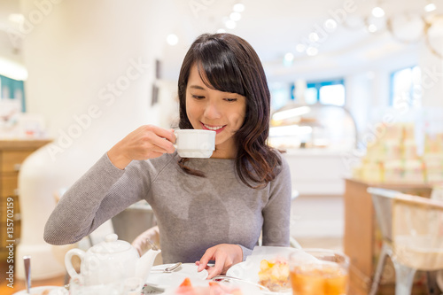Woman enjoy her coffee at cake shop