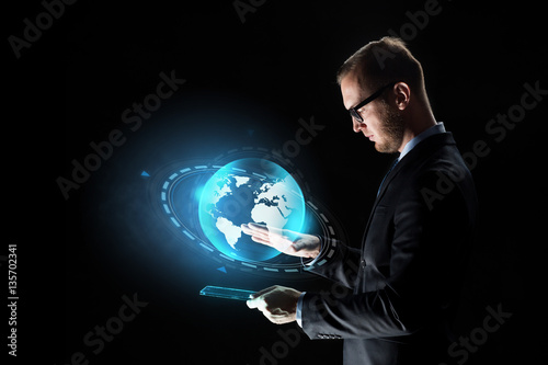 businessman with tablet pc and earth hologram