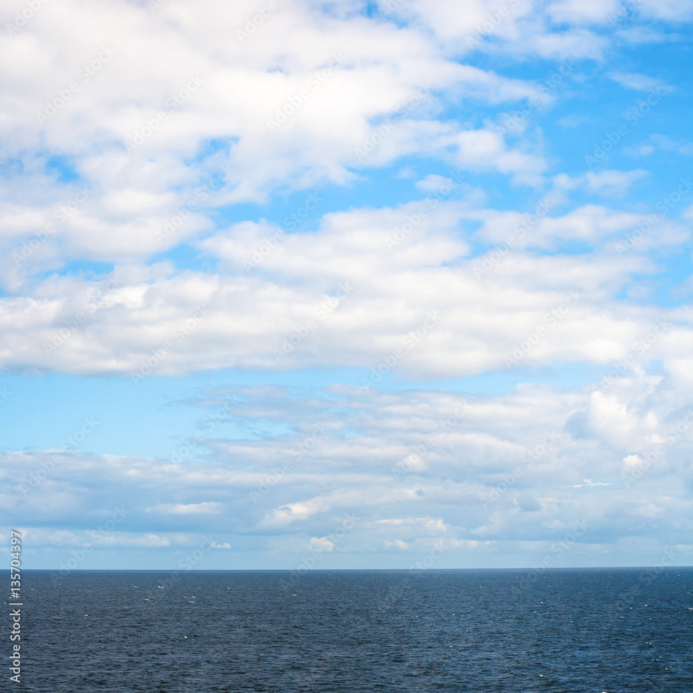 low white clouds in blue sky over Baltic Sea