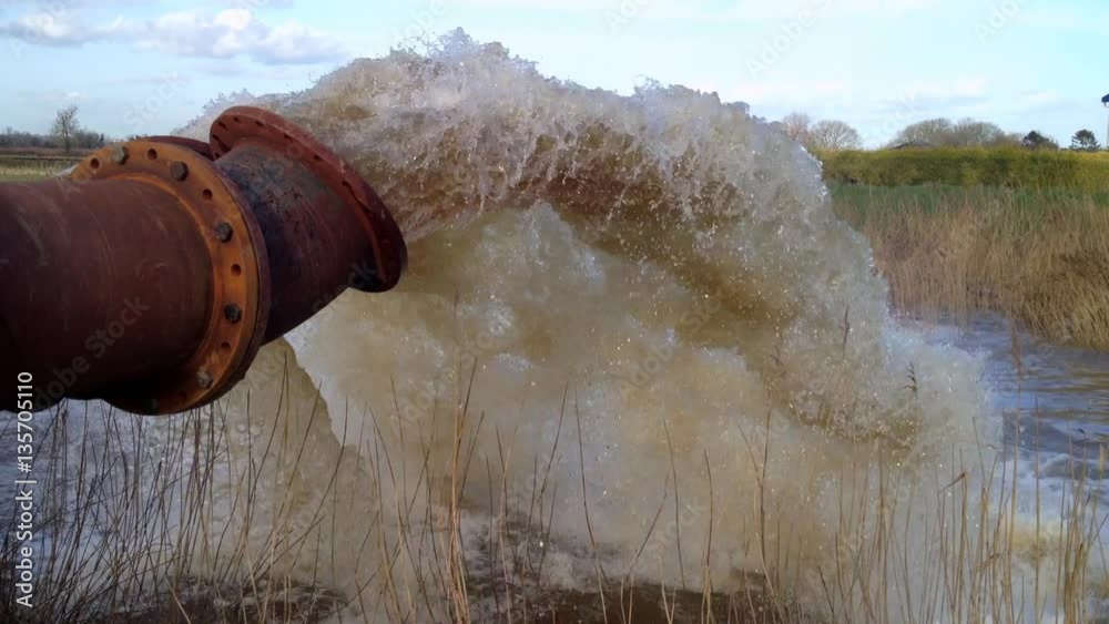 Massive flood pumps pumping flood water into the river. Massive flood pumps pumping flood water into the river.