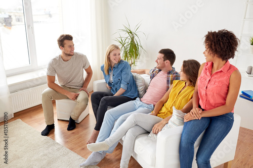 group of happy friends talking at home