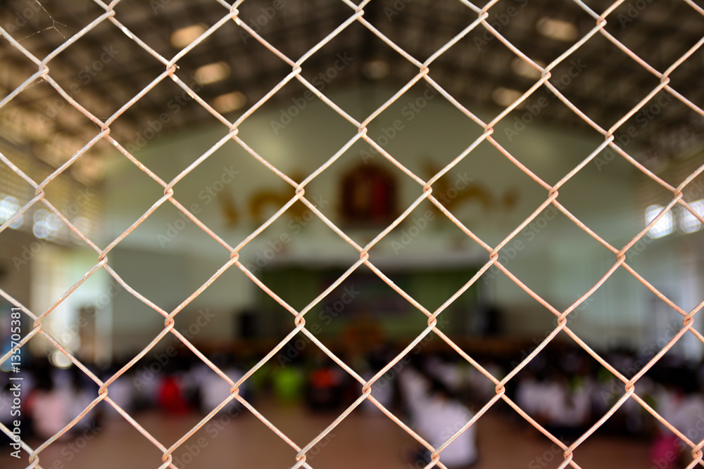 Fototapeta premium cage metal net and blur photo of student sit in auditorium