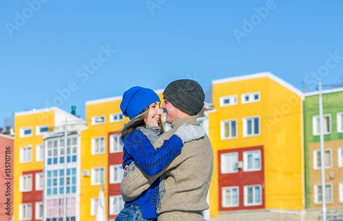 Young couple hugging and kissing background colored houses © Baikal360