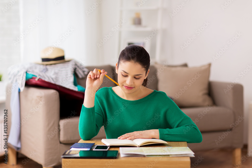 woman with notebook and travel map at home woman with notebook and travel map at home