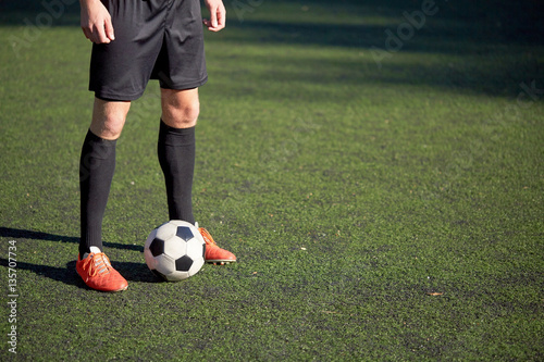 soccer player playing with ball on football field © Syda Productions