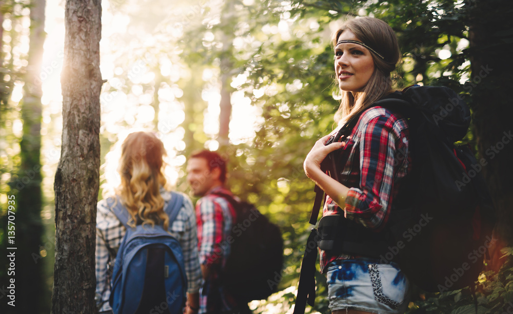 Group of backpacking hikers going for forest trekking