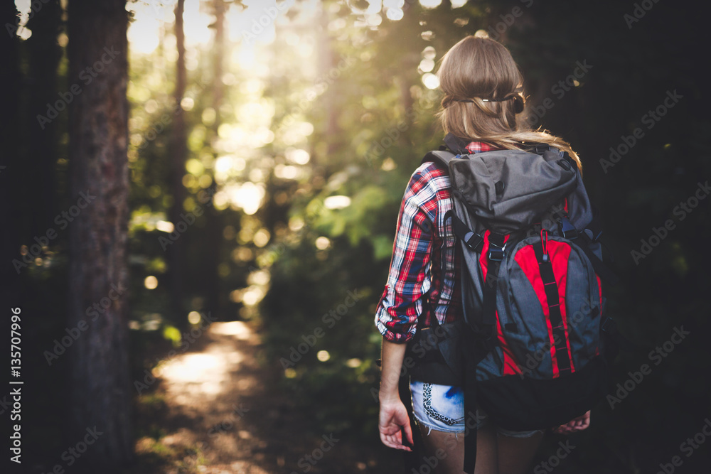 Female backpacker set out on forest trail