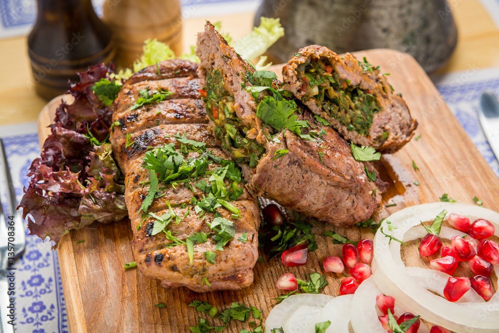 lula kebab with herbs on a wooden surface