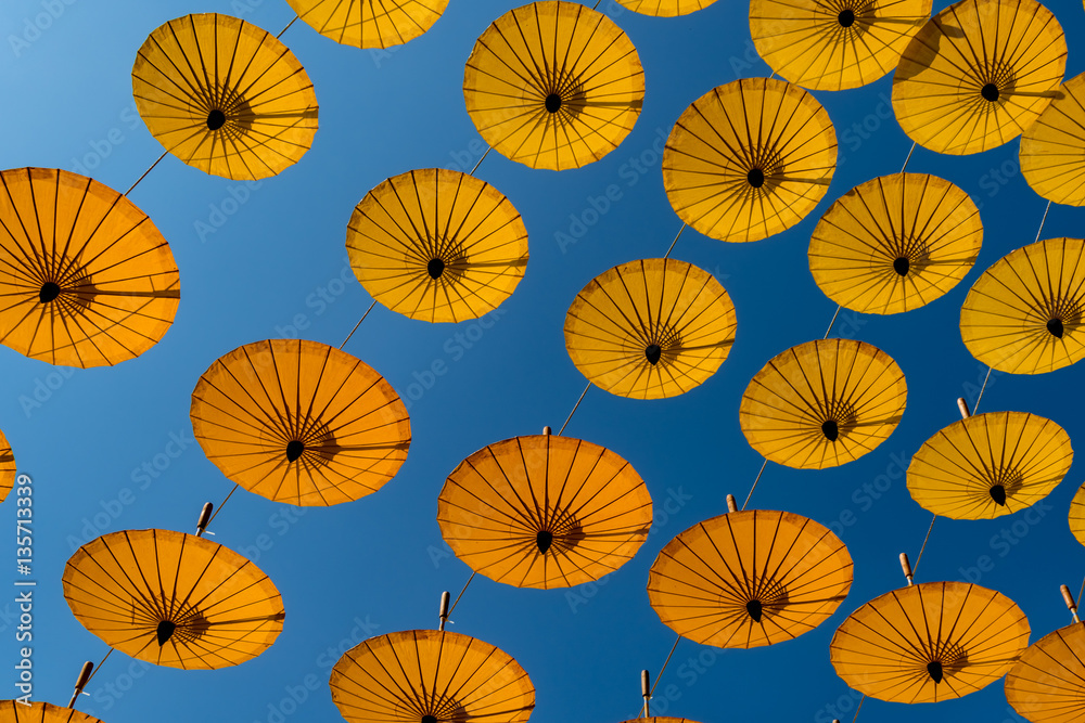 Naklejka premium Yellow umbrellas on blue sky