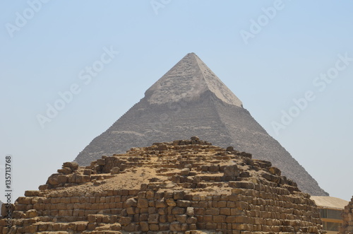 Pyramid in sand dust under gray clouds