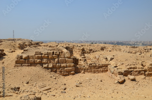 Pyramid in sand dust under gray clouds