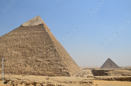 Pyramid in sand dust under gray clouds