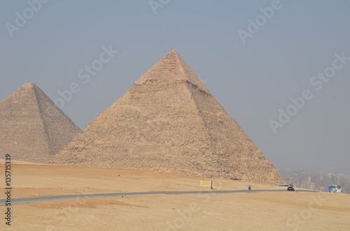 Pyramid in sand dust under gray clouds