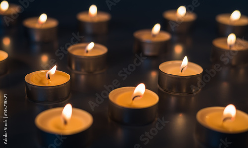 Flame of many candles burning on the background brown color