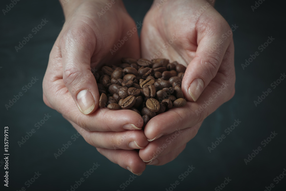 Lonely woman drinking coffee in the morning, top view of female hands holding cup of hot beverage on wooden desk, retro toned Lonely woman drinking coffee in the morning, top view of female hands holding cup of hot beverage on wooden desk, retro toned