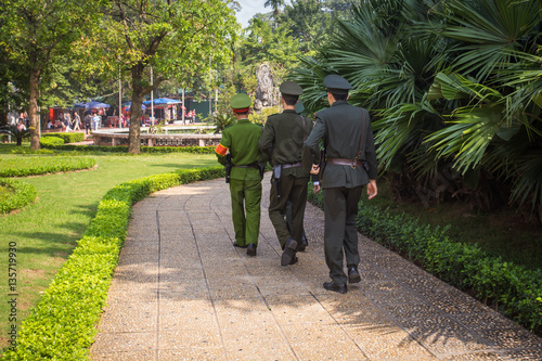Three soldiers marching through the park in Hanoi, Vietnam