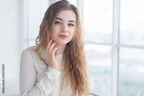Beautiful young woman by window