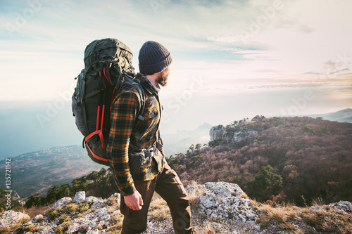 Man traveling with backpack hiking in mountains Travel Lifestyle success concept adventure active vacations outdoor mountaineering sport plaid shirt hipster clothing photo