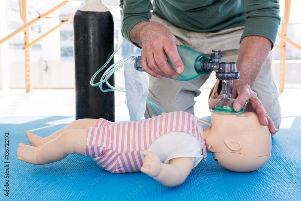 Paramedic practicing resuscitation on dummy Paramedic practicing resuscitation on dummy