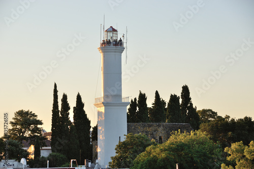 tourists on top of the lighthouse in Colonia del Sacramento, Uruguay, at sunset photo