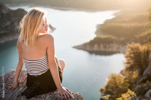 Chica rubia en soledad en las montañas photo