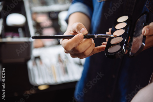 Close up of eyeshadow palette being held by a visagiste