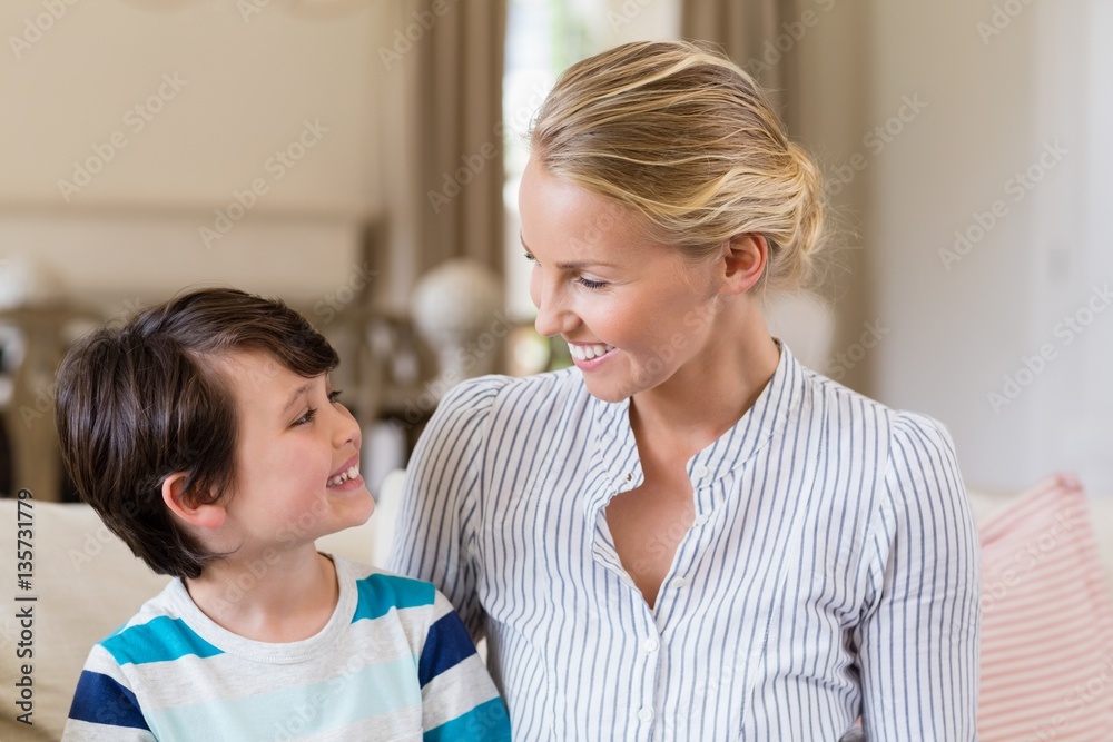 Smiling mother interacting with son in living room Smiling mother interacting with son in living room