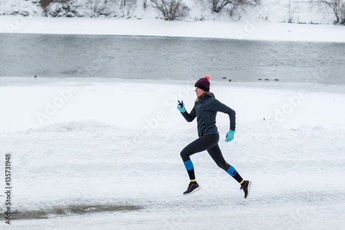 Young woman jogging in the winter park