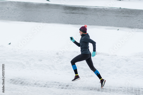 Young woman jogging in the winter park