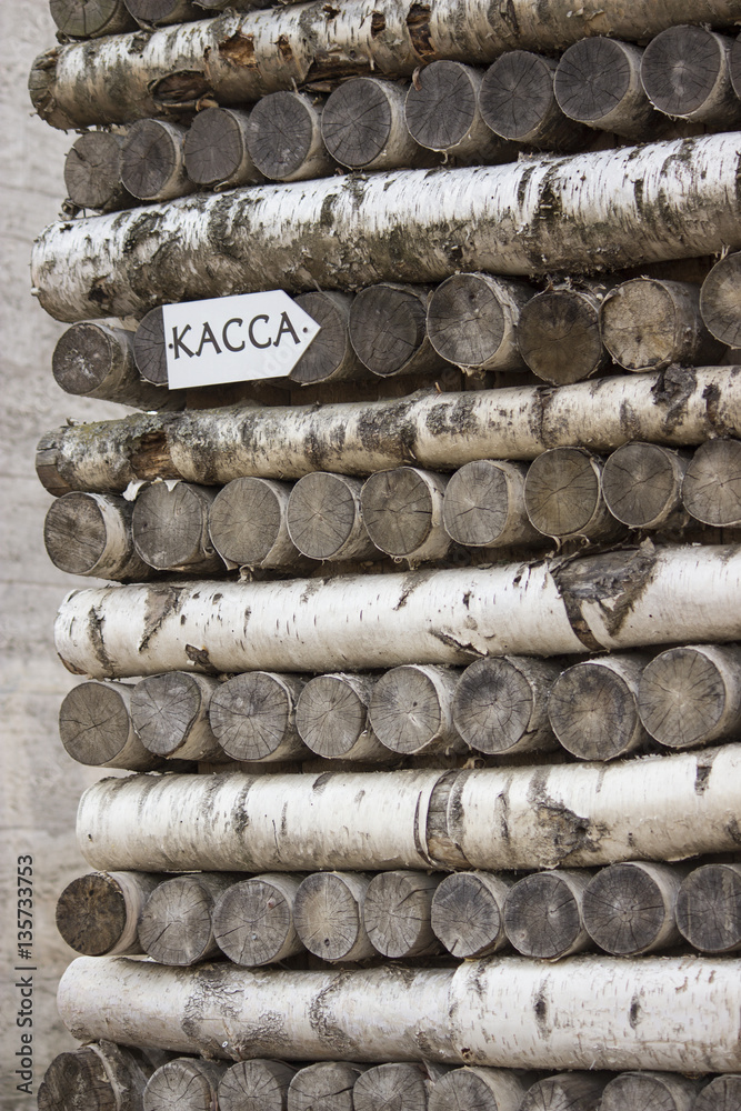 The wall of birch logs with a sign in Russian