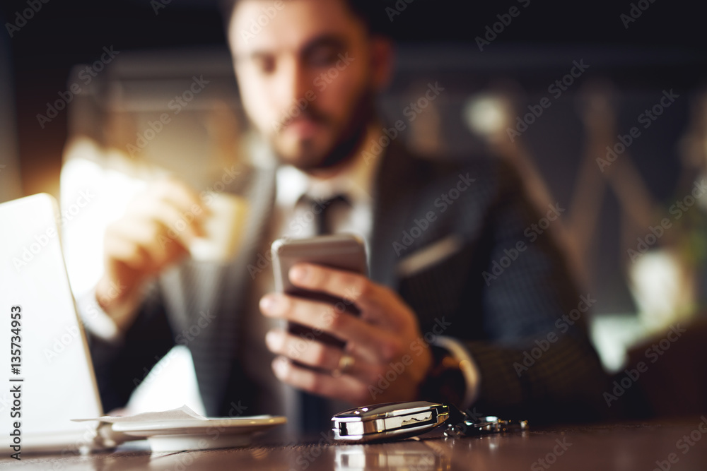 Businessman at restaurant, car key at focus. Businessman at restaurant, car key at focus.