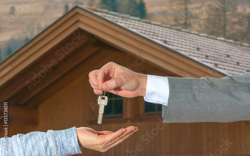 Woman buying new house. Closeup shot of a female hand receiving house key. Close up hand holding house key.