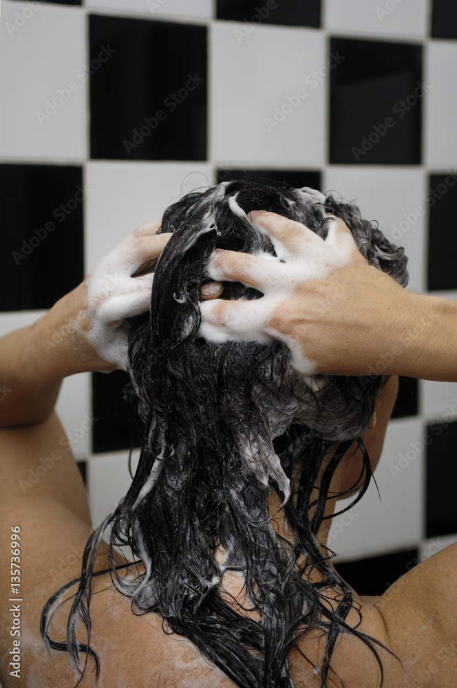 Naklejka premium Woman on her back washing her hair