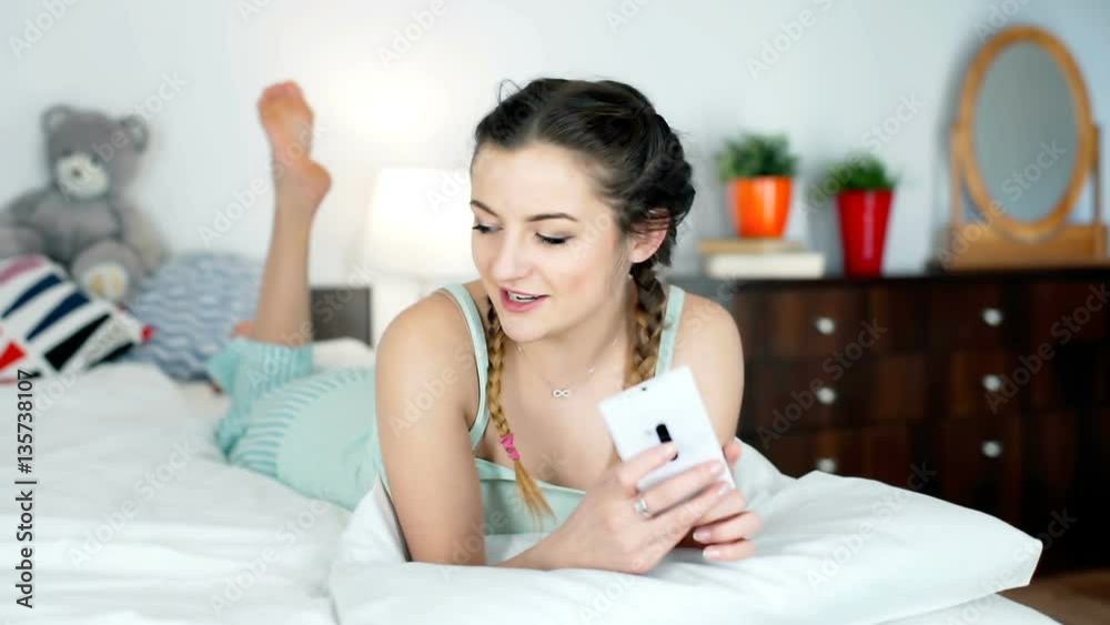 Happy teenager lying on the bed and having a videocall with someone, steadycam shot
Happy teenager lying on the bed and having a videocall with someone, steadycam shot
