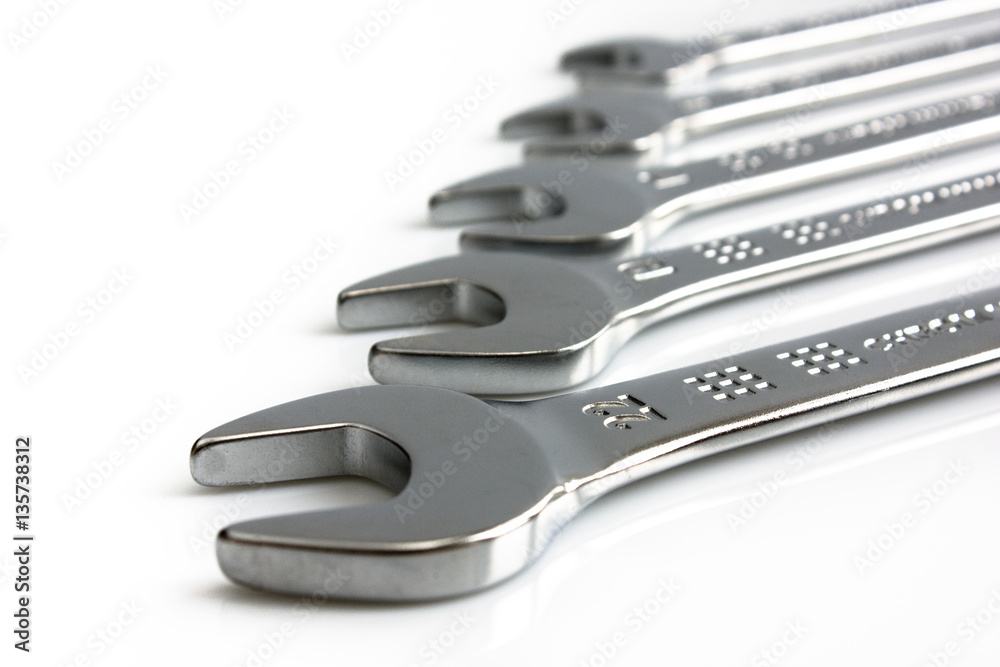 Fototapeta premium Four open end wrenches in a row, isolated on white background. Picture taken in studio with soft-box.