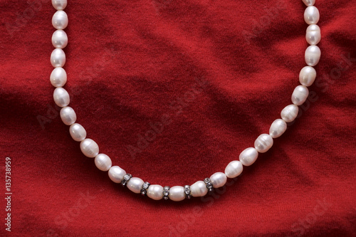 pearls and a pearl necklace on a red background for valentine day