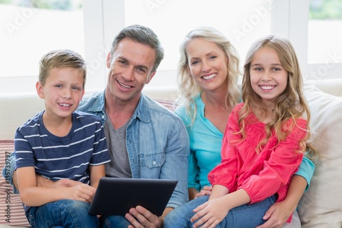 Smiling parents and kids sitting on sofa 