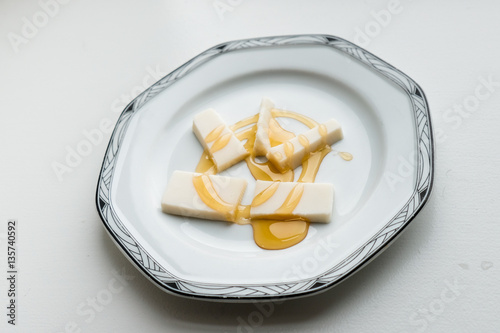 Simple dessert plate of cheese with drizzled honey.