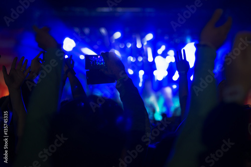 Crowd at concert recording atmosphere with their smart phones.