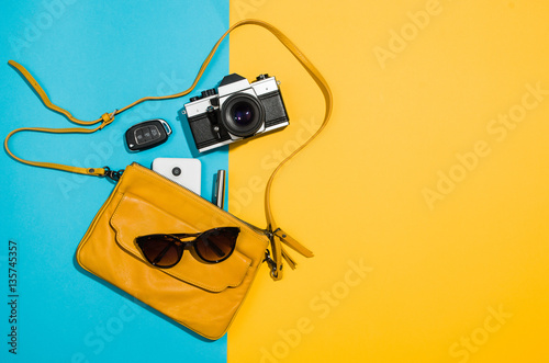 Woman's accessories flat lay on colorful background. Top view Blue and yellow pastel colors with copy space around products. Horizontal image or photograph.