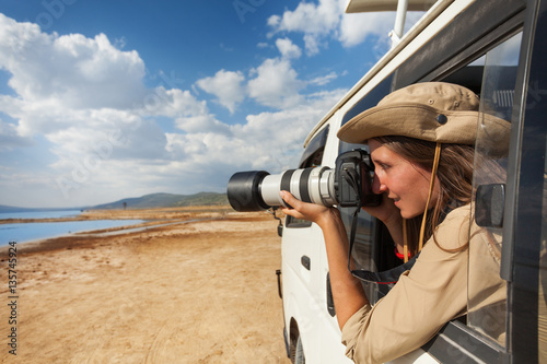 Girl taking photo from the window of safari jeep