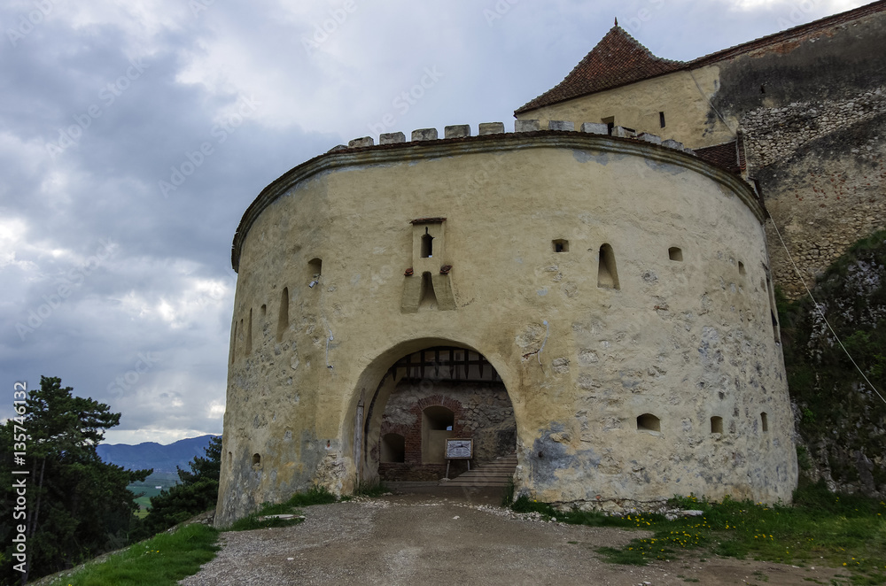 Gate tower of medieval fortress in Rasnov with mountains at background, Transylvania, Brasov, Romania