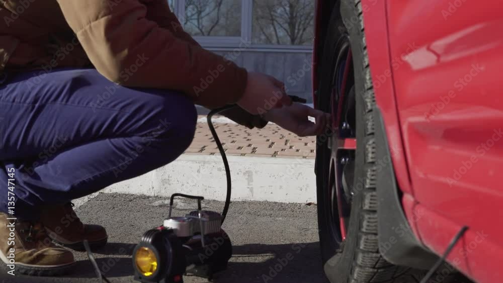 Closeup portrait of a man checking pressure and pumping a car tire. Closeup portrait of a man checking pressure and pumping a car tire.