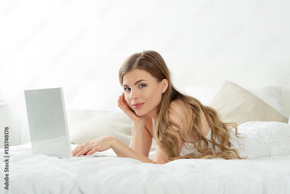 Natural beautiful woman with laptop on bed relaxing. Natural beautiful woman with laptop on bed relaxing.