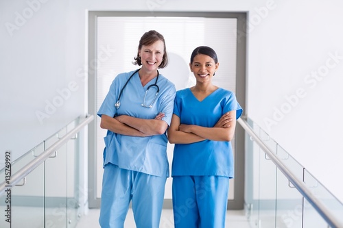 Portrait of smiling nurse and doctor standing with arms crossed