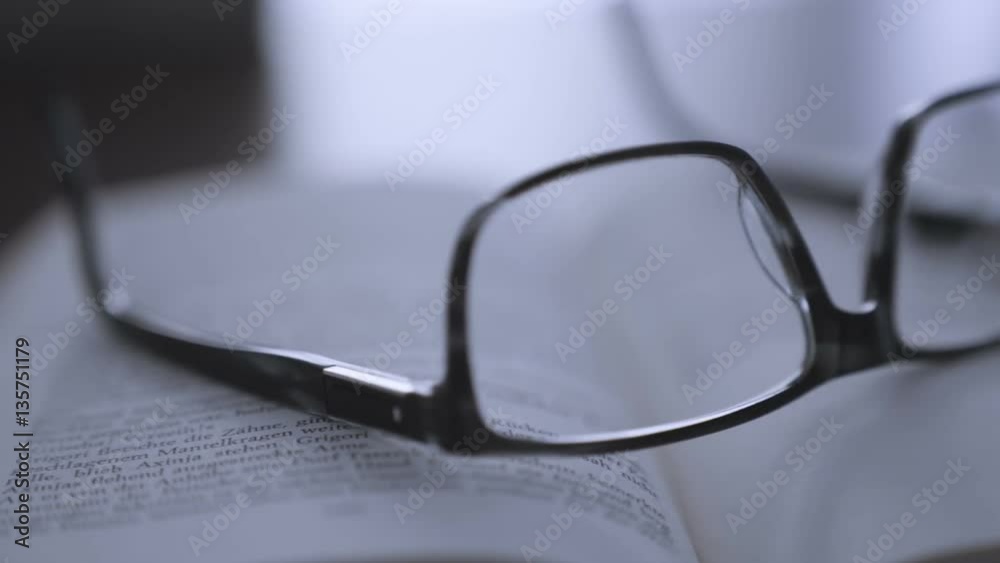 old books on desktop with modern glasses on open pages - vintage film style, smooth tracking shot old books on desktop with modern glasses on open pages - vintage film style, smooth tracking shot