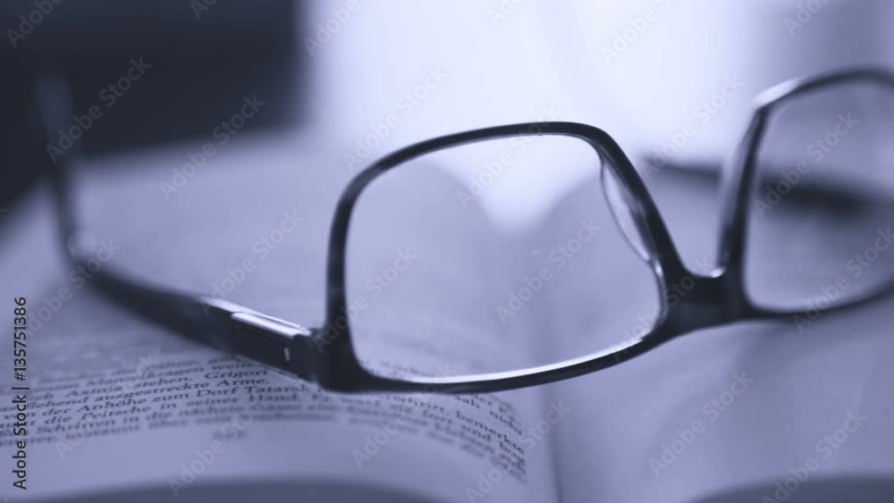 old books on desktop with modern glasses on open pages - vintage film style, smooth tracking shot old books on desktop with modern glasses on open pages - vintage film style, smooth tracking shot