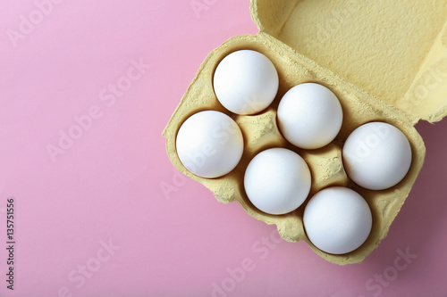 Obraz na plátne Raw eggs in package on pink background