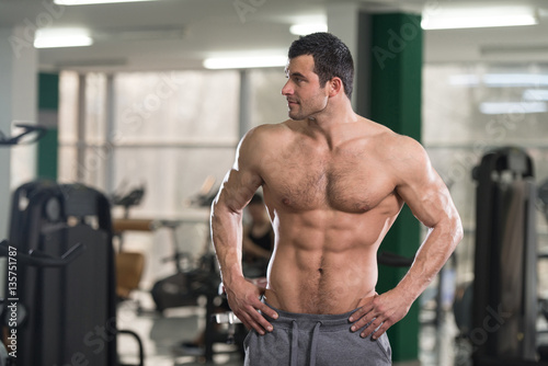 Hairy Muscular Man Flexing Muscles In Gym